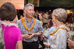 A group of three people engage in conversation while standing.