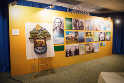 A bright yellow gallery wall displays several historical images.