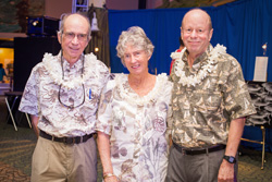 A group of three pose for a photograph at an event.