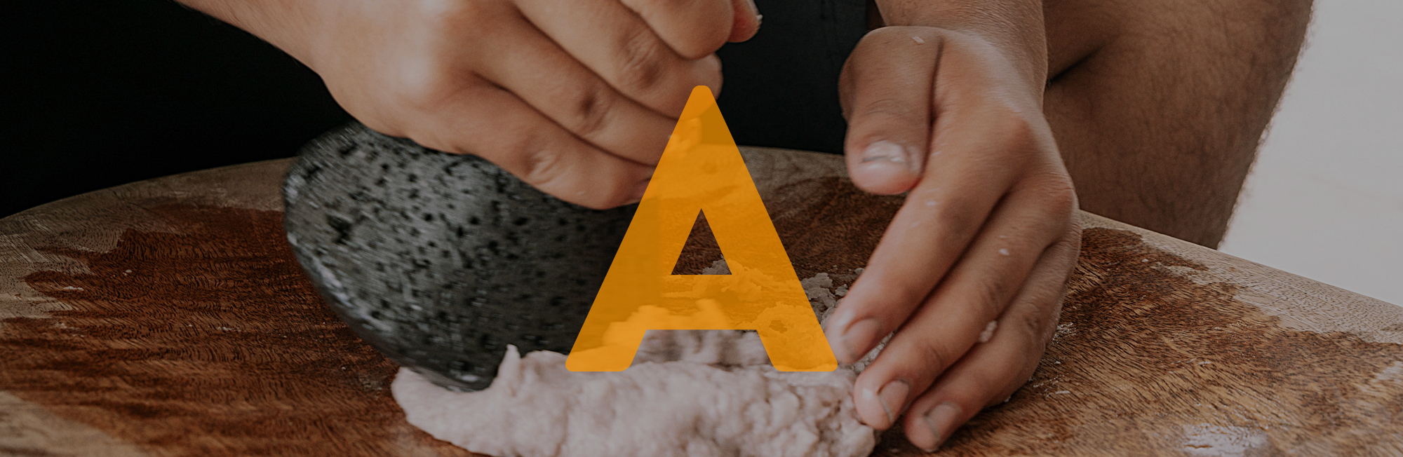 Image showing hands sculpting with a rock tool. The letter A is shown on top of the image.